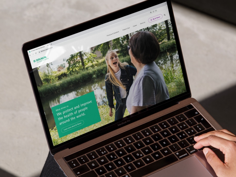 Ein Laptop mit geöffneter B. Braun Website und einer Hand, die unten rechts auf dem Laptop ruht. 