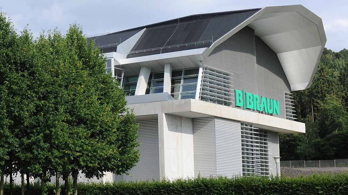 B. Braun Besucherzentrumsgebäude mit großem B. Braun Logo, das ein Gefühl von Gastfreundschaft und Offenheit gegenüber allen, die sich nähern, ausstrahlt. 