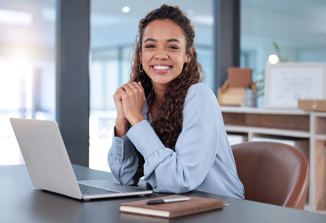 Junge Frau am Laptop im Büro sitzend