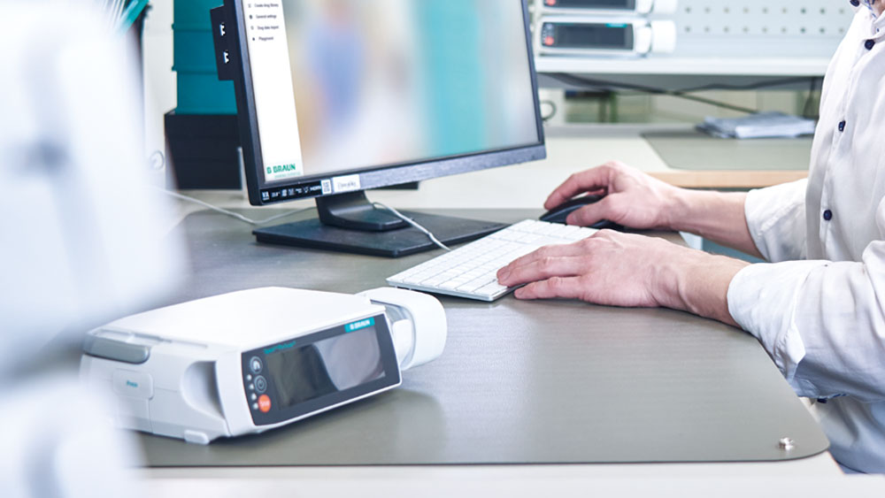 Jemand sitzt vor einem PC – es steht auch eine Space-Pumpe auf dem Schreibtisch