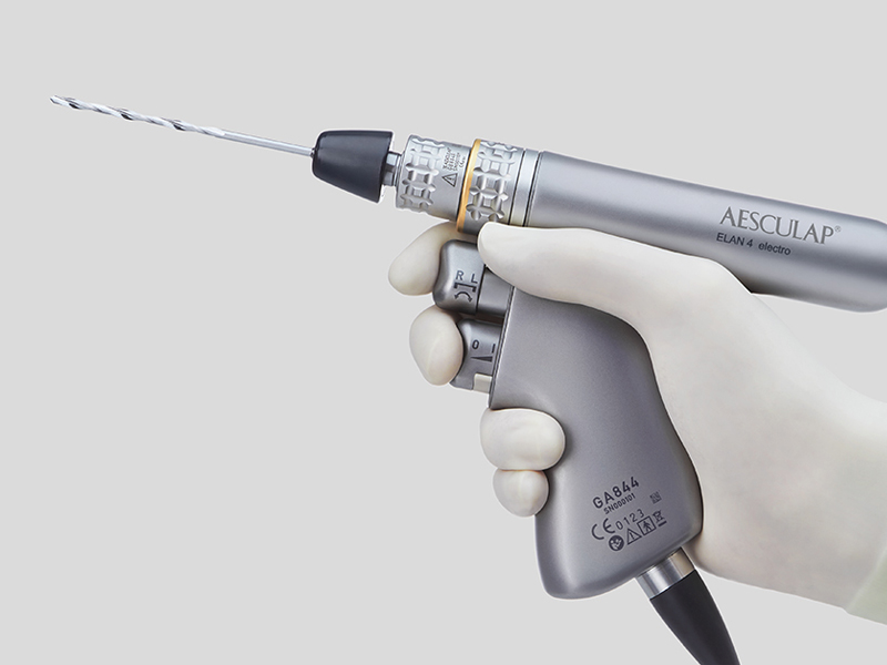 Ein chirurgisches Motorensystem wird mit einer Hand mit Handschuh gehalten