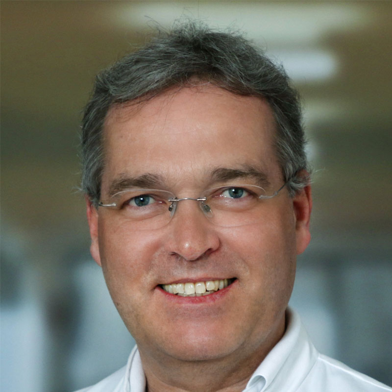 Porträt von Professor Dr. Markus Golling im Arztmantel, der selbstbewusst in die Kamera lächelt